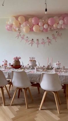 a dining room table with balloons hanging from the ceiling