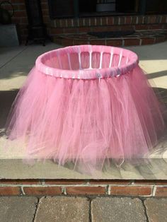 a pink tulle skirt sitting on top of a sidewalk