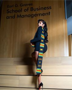 a woman is standing on some steps in front of a wall with the words school of business and management