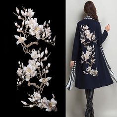 the woman is wearing a black coat with white flowers on it