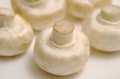 several white mushrooms sitting on top of a table