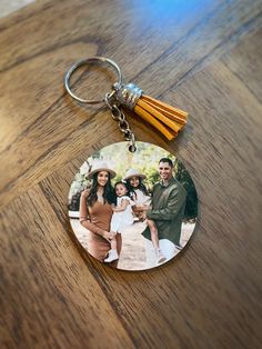 a keychain with an image of two people and a tassel on it