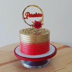 a red and gold cake sitting on top of a wooden table