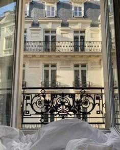 an open window with a view of a balcony and building in the backround