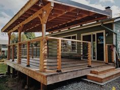 a wooden deck with metal railings next to a house