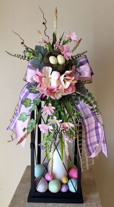 a vase filled with flowers and eggs on top of a table