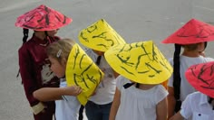 several children wearing hats with drawings on them