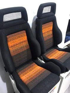 two black seats with orange and yellow seat covers