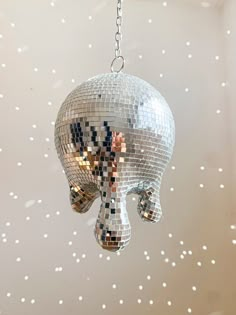 a disco ball shaped like an elephant hanging from a chain