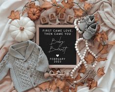 a baby's birth announcement surrounded by fall leaves and other items on a blanket