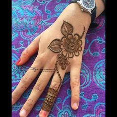 a woman's hand with henna tattoos on it