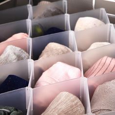 several pairs of socks are stored in plastic bins with dividers to keep them organized