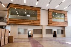 the inside of an empty building with boxes on the floor and windows in the wall