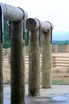 several wooden posts are lined up in front of a fence