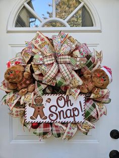 a christmas wreath that says oh snap with teddy bears hanging on the front entrance door