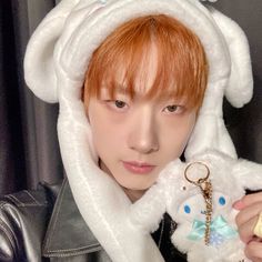 a person wearing a bunny costume holding a teddy bear keychain in front of their face