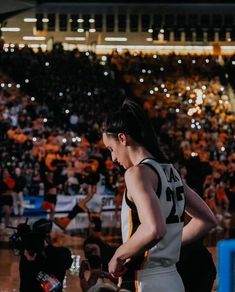 a female basketball player standing in front of an audience