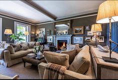 a living room filled with furniture and a fire place in the middle of a room