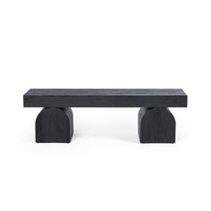 a wooden bench sitting on top of a white floor next to a black object with two legs