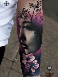 a woman's leg with flowers on it and a face in the middle of her arm