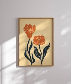 an orange and black flower on a beige background in a wooden frame hanging on the wall