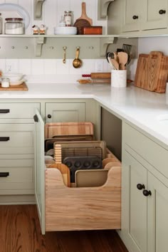 an organized kitchen with wooden utensils in the drawer