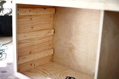 the inside of a wooden box is being built with plywood boards and screws