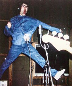 a man is jumping in the air with his guitar