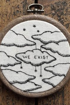 a hand embroidered badge with the words we existt in black and white on it