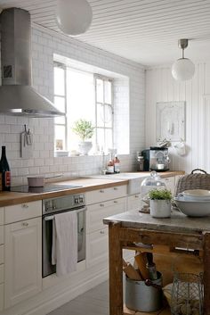 a kitchen filled with lots of white appliances and counter top space next to a window