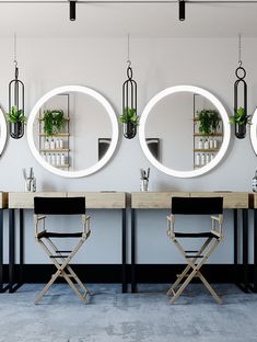 three round mirrors hanging on the wall above two desks with chairs in front of them