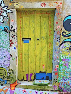 a yellow door is painted with flowers and birds