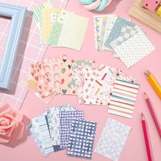 several pieces of paper laid out on a pink surface