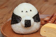 a plate topped with rice and meat next to a piece of bread on top of it