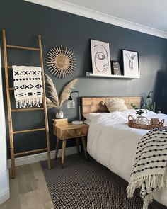 a bed room with a neatly made bed and a ladder on the wall above it