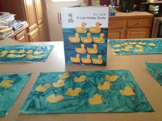 paper plates with rubber ducks on them sitting on a kitchen counter next to a book