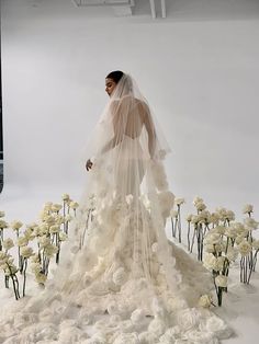 a woman in a wedding dress surrounded by flowers