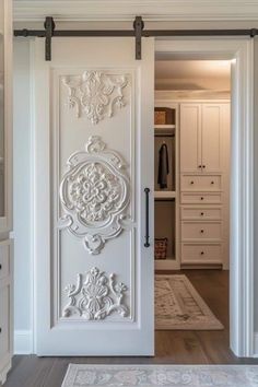 a white door with an ornate design on the front and side panels, is open to reveal