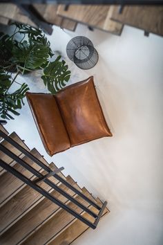 an open book sitting on top of a wooden table next to a fan and plant