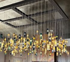 a chandelier hanging from the ceiling in a room with wooden paneling and metal rods