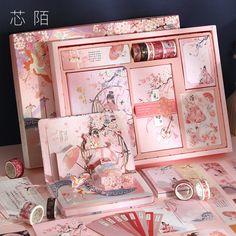 a table topped with lots of pink cards and boxes filled with different types of items