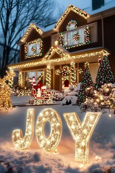 the word joy is lit up in front of a house with christmas lights