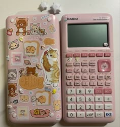 a pink calculator sitting on top of a table next to another calculator