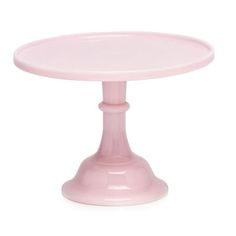 a pink cake plate sitting on top of a white table