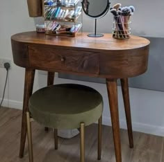 a wooden desk with a mirror and stool