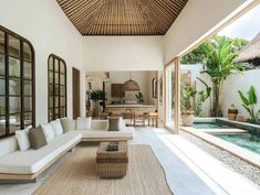 a living room with couches and tables next to a pool