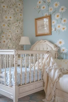 a white crib in a blue room with flowers on the wall and bedding