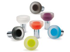 several different colored glass knobs on white surface