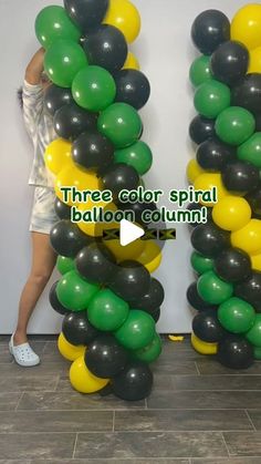 a woman standing next to two giant balloons in the shape of letters that spell three color spiral balloon columns