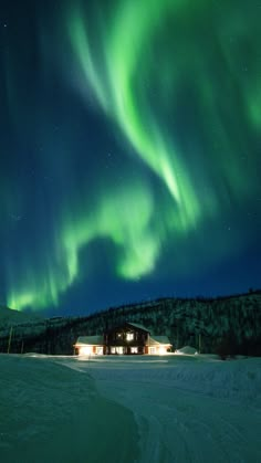 the aurora lights shine brightly in the night sky over a snow - covered field and cabin